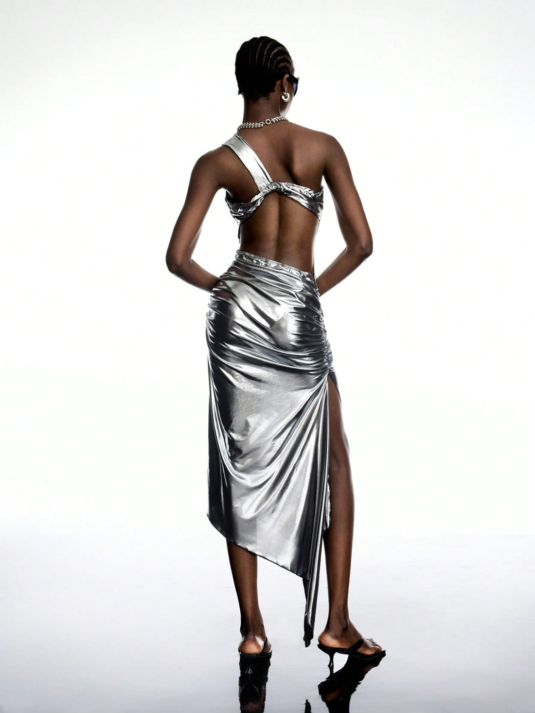 Turn heads in this chic one-shoulder metallic dress, designed with a ruched backless detail that adds a flirty edge. Perfect for club nights, its shimmering fabric catches every light, making you the star of the party. Dance the night away in style and confidence with this playful, standout outfit.