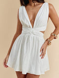Close-up white sleeveless mini dress with plunging V neckline and twist waist