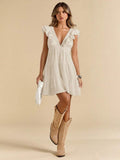 White mini dress with ruffle V neckline tiered skirt silver cuff and tan cowboy boots