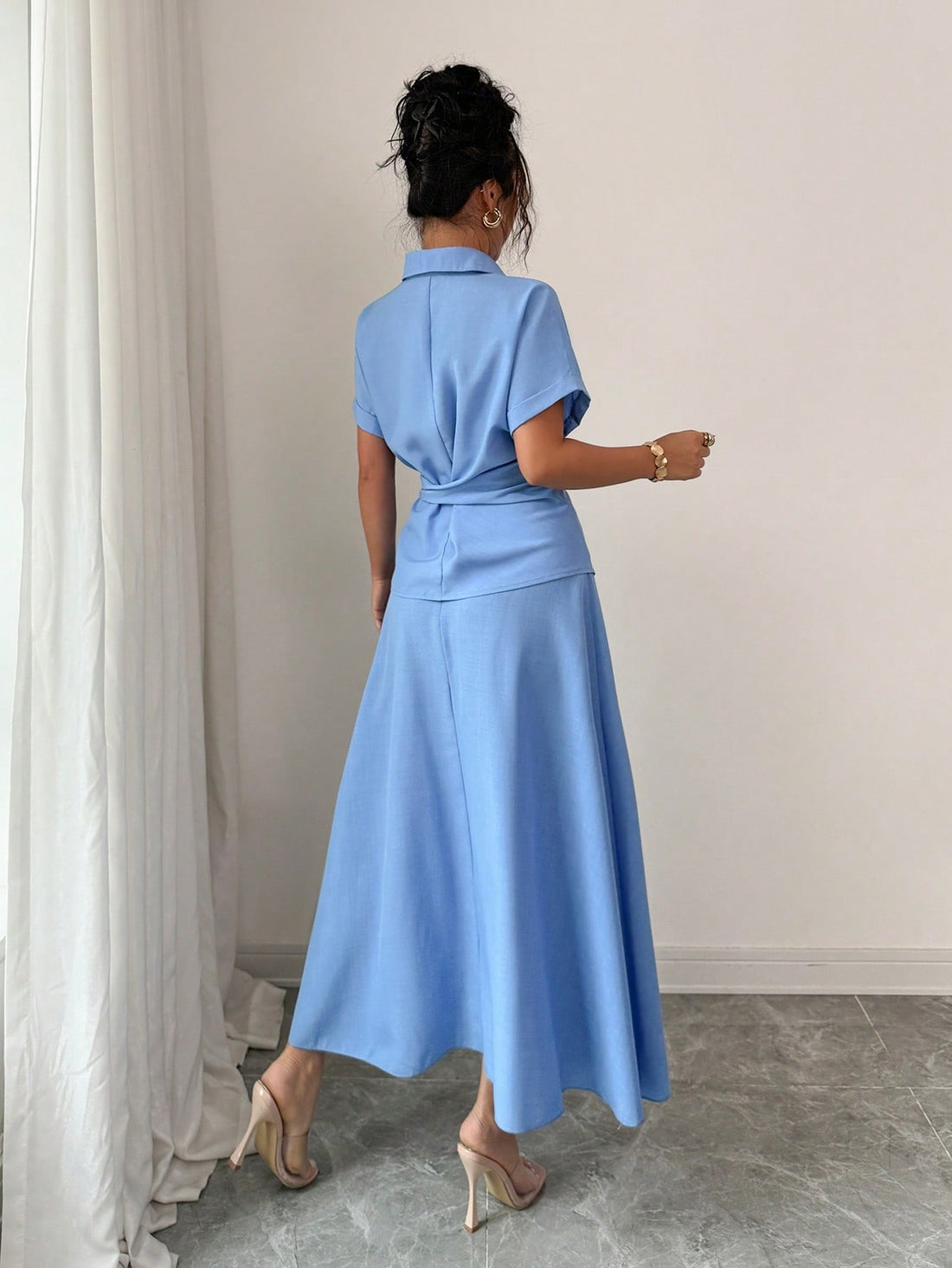 Elevate your warm-weather wardrobe with this breezy two-piece set designed for effortless style. The relaxed short-sleeve top pairs perfectly with the flattering half skirt, creating a versatile look that transitions seamlessly from casual hangouts to weekend adventures. Crafted in a cool blue hue that complements any complexion, this set strikes the perfect balance between comfort and trendiness. Whether you're catching up with friends or exploring the city, you'll feel confident and put-together in this s