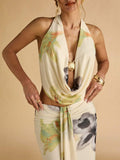 Side view of floral cowl top and slim draped maxi skirt with front sash