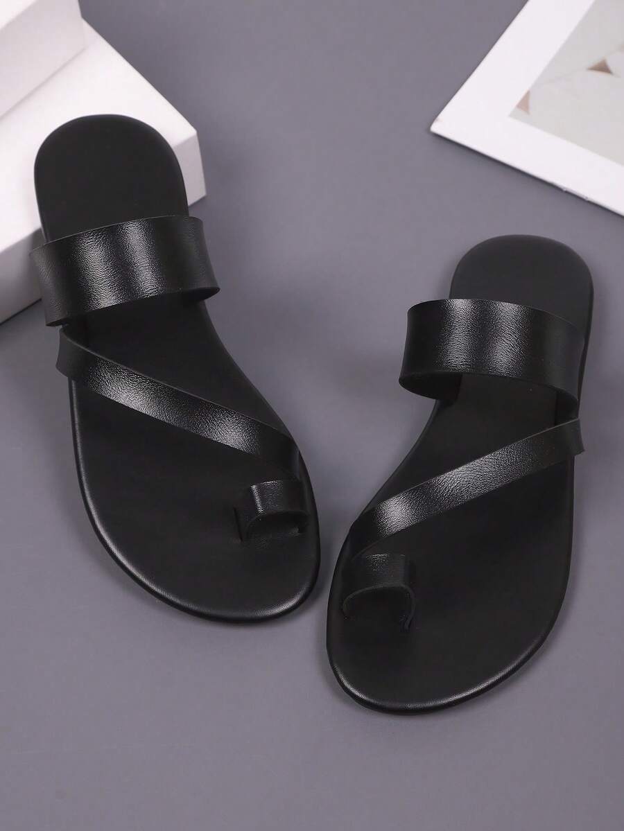 Front view of black flat slide sandals with toe loop and wide PU leather strap for casual wear