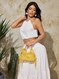 Yellow crochet beach bag carried by model with white outfit and cactus background