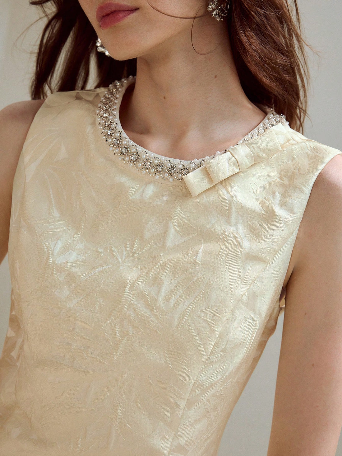 Turn heads with this playful jacquard dress featuring a sparkling rhinestone and faux pearl bow detail. Its sleeveless, short design keeps things flirty and fun, perfect for dancing the night away or making a stylish statement at any event. Embrace charm and confidence in one chic package!