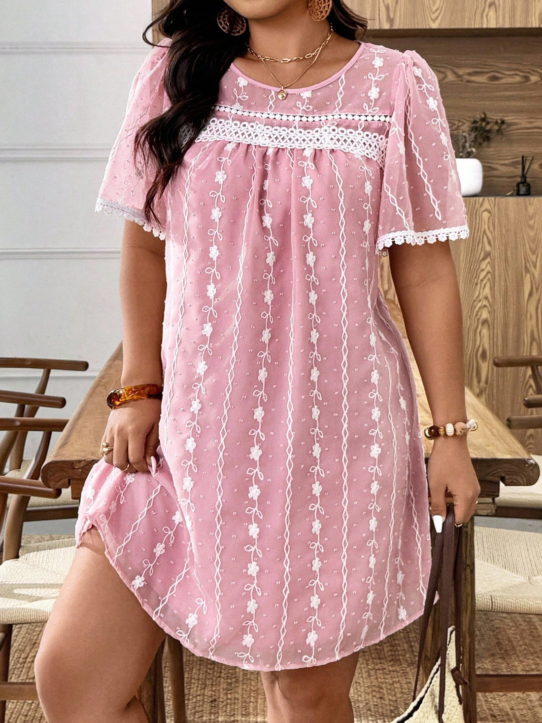 Twirl into the spotlight with this charming plus-size mini dress that celebrates your curves with style! Featuring delicate embroidered details and a flirty frilly trim, this short-sleeve beauty strikes the perfect balance between sophisticated and fun. The flattering cut ensures you'll feel confident and fabulous whether you're heading to brunch, a night out, or any occasion that calls for effortless elegance. Comfort meets fashion in this must-have piece that proves you can absolutely slay in something th