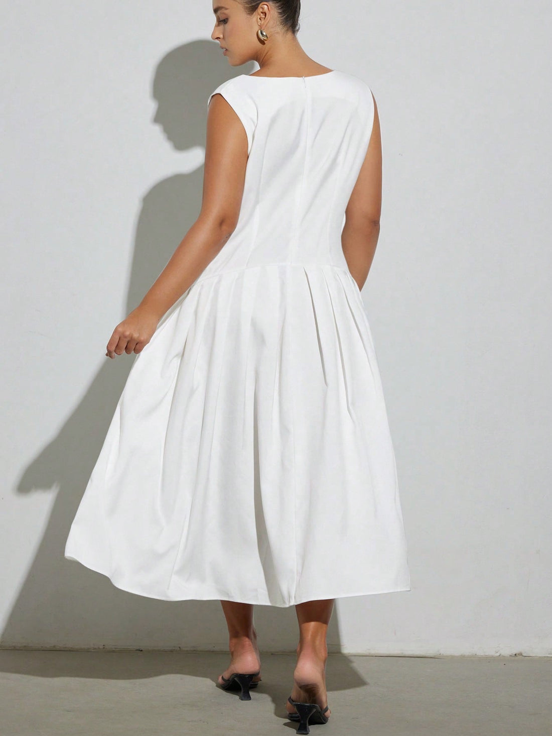 Turn heads effortlessly in this chic plus size white sleeveless dress, featuring a stylish one-shoulder hem that adds a flirty twist. The pleated patchwork detail brings texture and movement, making every step feel like a dance. Perfect for sunny days or evening fun, this dress combines comfort with playful elegance.