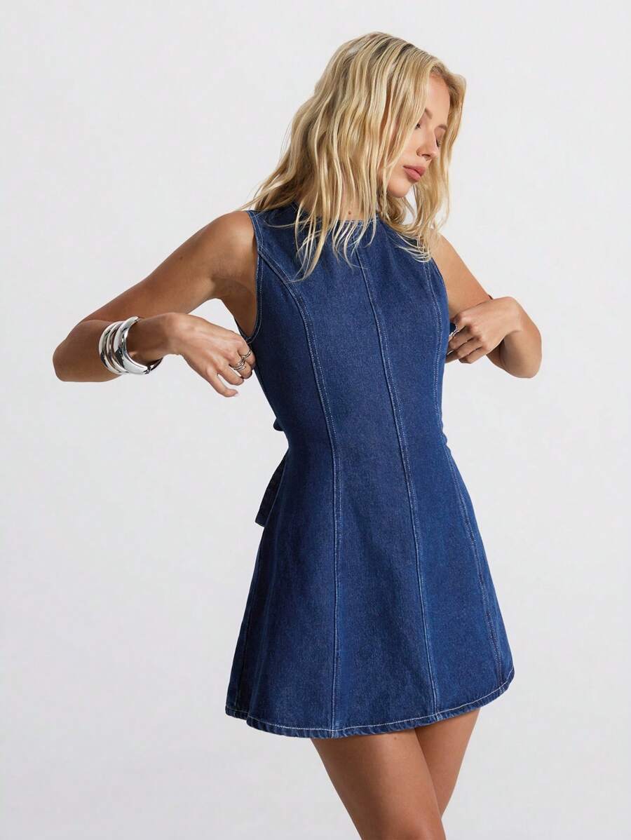Three-quarter front view of dark indigo backless denim mini dress with fitted princess seams