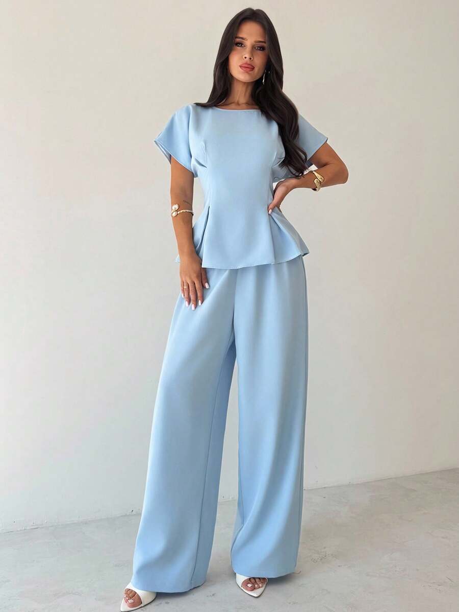 Elevate your professional wardrobe with this sophisticated 2-piece office set, designed for the modern woman who values both style and comfort. The ensemble features a graceful pleated blouse with batwing sleeves and a round neckline, paired with elegant wide-leg pants that create a flattering silhouette. Crafted from a premium blend of 94% polyester and 6% elastane, this set offers durability and subtle stretch for all-day wearability. 