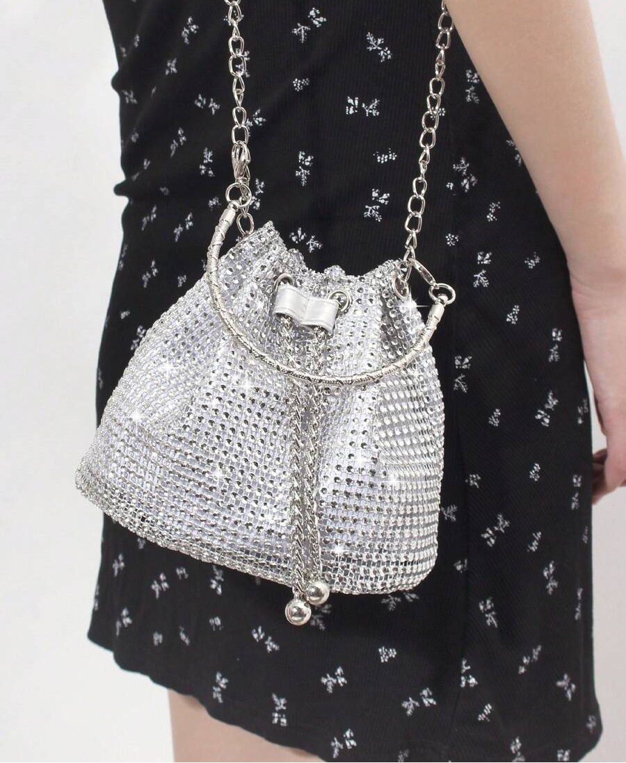 Elevate your everyday carry with this stunning gold bucket tote that's equal parts glamorous and practical. Adorned with shimmering rhinestone embellishments, it catches the light beautifully whether you're heading to the office, jetting off on an adventure, or making an entrance at your next event. The spacious bucket silhouette keeps your essentials organized while the polished gold finish adds that touch of sophistication you've been craving. Versatile enough to transition from day to night, this tote is