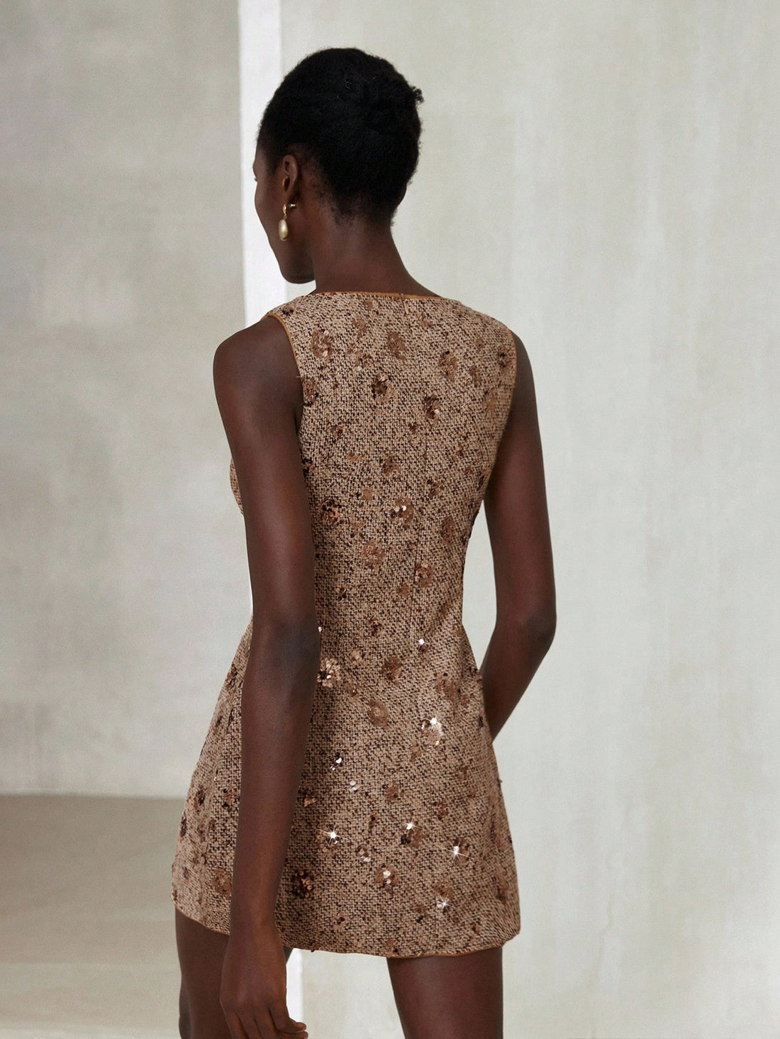 Step into the spotlight with this Elegant Brown Tweed Mini Dress, sprinkled with subtle sequins for just the right amount of sparkle. Perfectly tailored for a high-end minimalist look, it’s your go-to for turning heads at the office or during your daily commute. Cozy tweed meets chic design—because who says workwear can’t have a little fun?