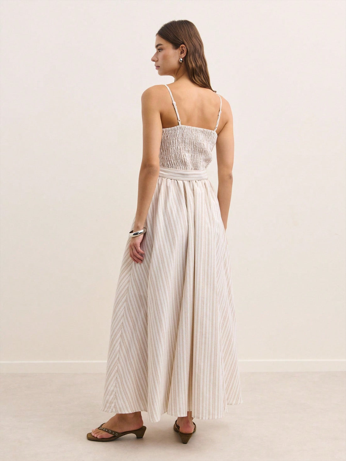 Effortlessly chic meets comfort in this stunning beige maxi dress! Featuring delicate smocking details that add texture and visual interest, wide straps for a flattering fit, and a coordinating belt to cinch your silhouette just right. The flowing maxi length keeps things elegant while the neutral tone pairs beautifully with everything in your closet. Whether you're heading to a summer garden party or layering up for crisp fall days, this versatile piece transitions seamlessly through the seasons. Dress it 