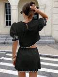 Back view black two piece set with white scallop trim, puff sleeves, and keyhole tie crop top