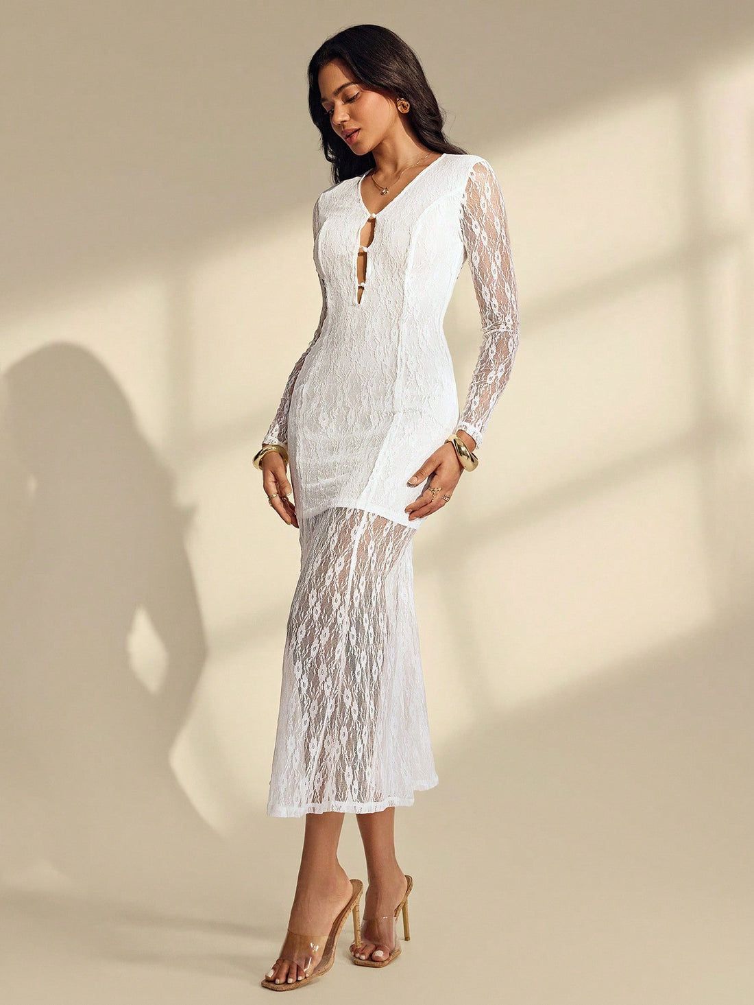 Slip into timeless elegance with this stunning white lace gown that's equal parts romantic and show-stopping. The plunging V-neckline draws eyes upward, while delicate ruching hugs your curves in all the right ways, leading to a dramatic fishtail hem that swishes with every step. Long sleeves add an air of sophistication, and the floor-length silhouette ensures you'll feel like the main character at any event. Perfect for weddings, galas, or whenever you want to turn heads and feel absolutely fabulous.
