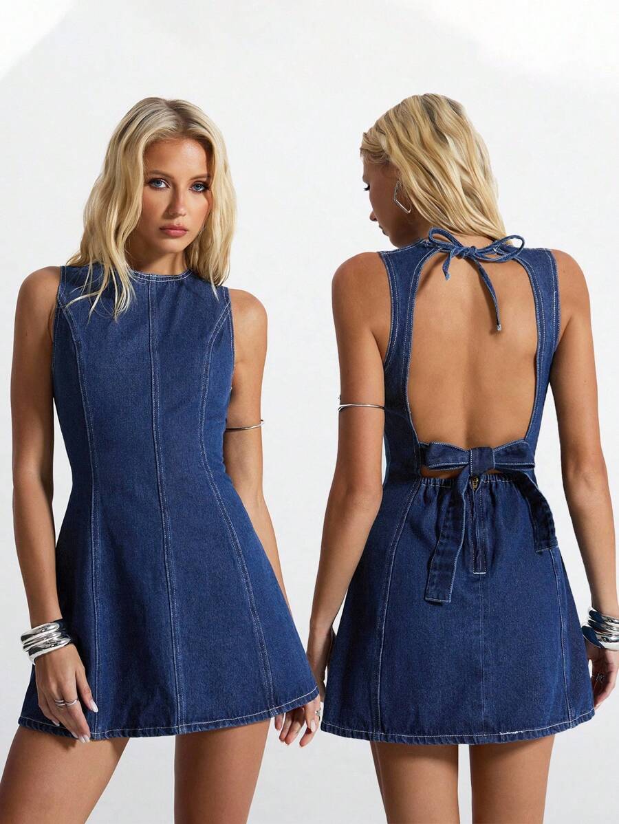 Front studio view of dark indigo sleeveless denim mini dress with sculpted seams and A-line skirt