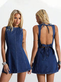 Front and back view of dark indigo denim mini dress showing deep open back and tie waist