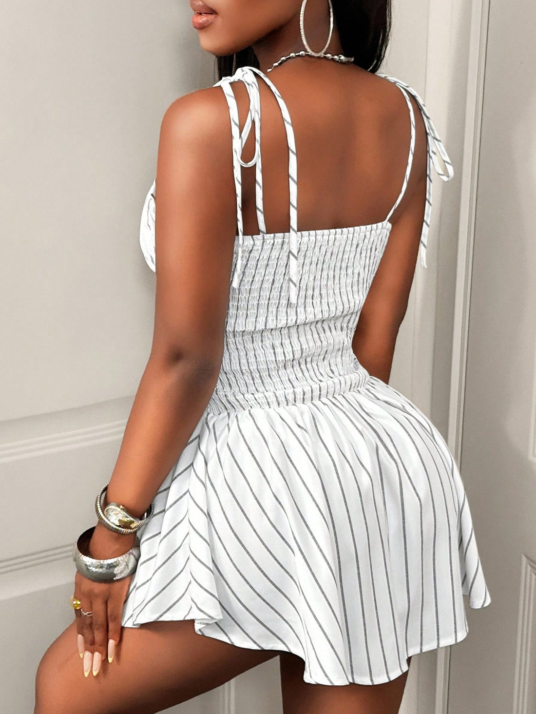 This playful mini dress features chic stripes and delicate spaghetti straps, making it your go-to for breezy summer days. Its flattering fit and lightweight fabric keep you cool and stylish, whether you're headed to a picnic or a sunset stroll. Effortless charm has never looked so fun!