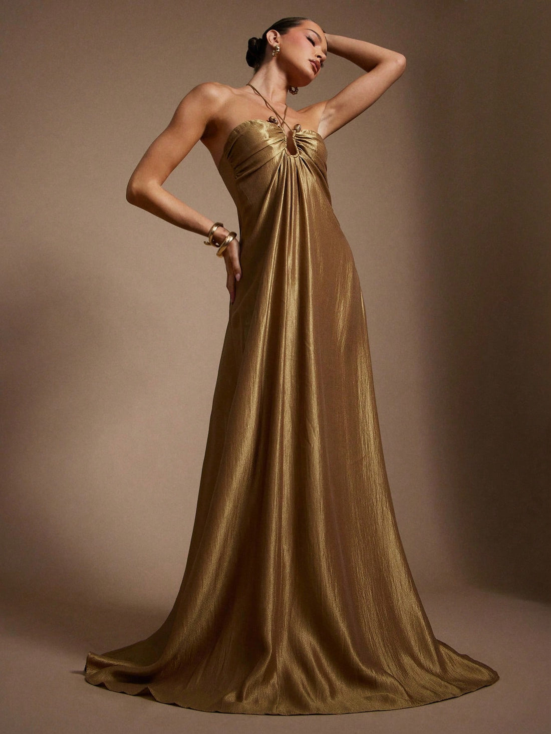 Slip into pure glamour with this stunning gold satin maxi dress, designed to turn heads at every summer soirée. The luxurious drape at the front creates an effortlessly chic silhouette, while the delicate ornament detail adds just the right touch of sparkle. Perfect for evening events, romantic dinners, or nights when you want to feel absolutely radiant. This dress moves like a dream and photographs beautifully—because every moment deserves to shimmer.