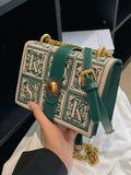 Side view of cream green box crossbody bag with gusseted body and gold hardware