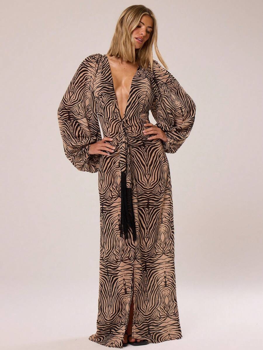 Step into the spotlight with this playful zebra print maxi dress, designed to dazzle at any spring or summer occasion. Its deep V-neck adds a flirty touch, while the charming tassel details bring movement and fun. Perfect for weddings and festivals alike, this dress combines wild prints with elegant flow, making you the life of the party wherever you go.