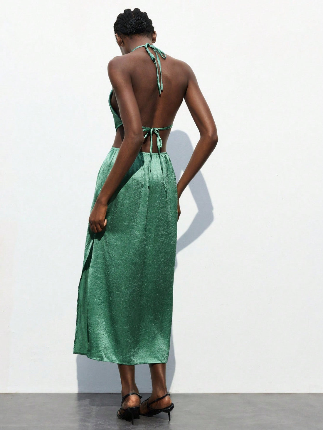 Turn heads in this stunning sage green ruched dress that's equal parts sophisticated and fun. The halter neckline and daring backless design create an effortlessly chic silhouette perfect for making a statement at parties, weddings, or tropical getaways. Ruching details add flattering dimension while keeping things playful and modern. Whether you're dancing the night away or sipping cocktails on deck, this versatile piece transitions seamlessly from celebration to celebration. Dress it up with heels and jew