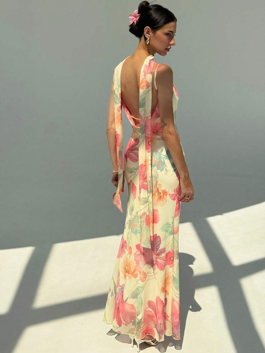 Elevate your garden party ensemble with this enchanting floral dress, designed to captivate with its delicate details. The sheer mesh construction showcases an exquisite floral pattern while the backless silhouette and spaghetti straps create an effortlessly sophisticated look. A flowing scarf collar adds movement and elegance, framing the neckline beautifully. Perfect for outdoor celebrations, this dress balances femininity with modern style, offering a memorable impression at any garden gathering.