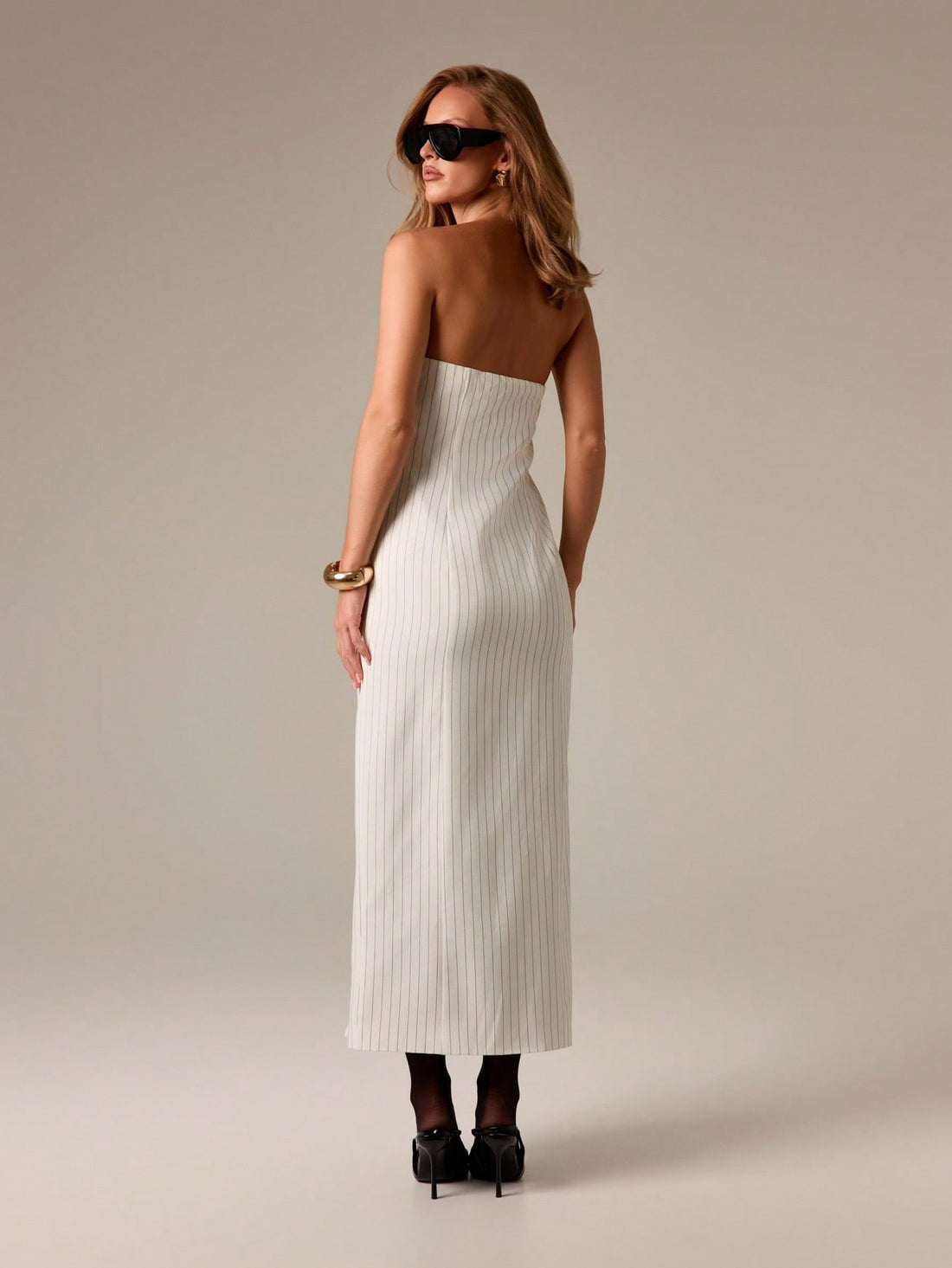 Step into sunshine and starlight with this Elegant Pinstripe Bandeau Maxi Dress! Its sleek pinstripe pattern and flirtatious front slit keep things effortlessly chic, while the strapless bandeau design lets you show off your sun-kissed shoulders. Perfect for summer vacations or lively evening parties, this dress blends comfort with a playful vibe to keep you dancing all night long.