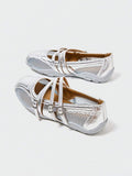 Rear-side view of silver buckle-strap Mary Jane flats with mesh panels and low gray sole
