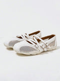 Front three-quarter view of white three-strap Mary Jane flats with mesh panels and segmented sole