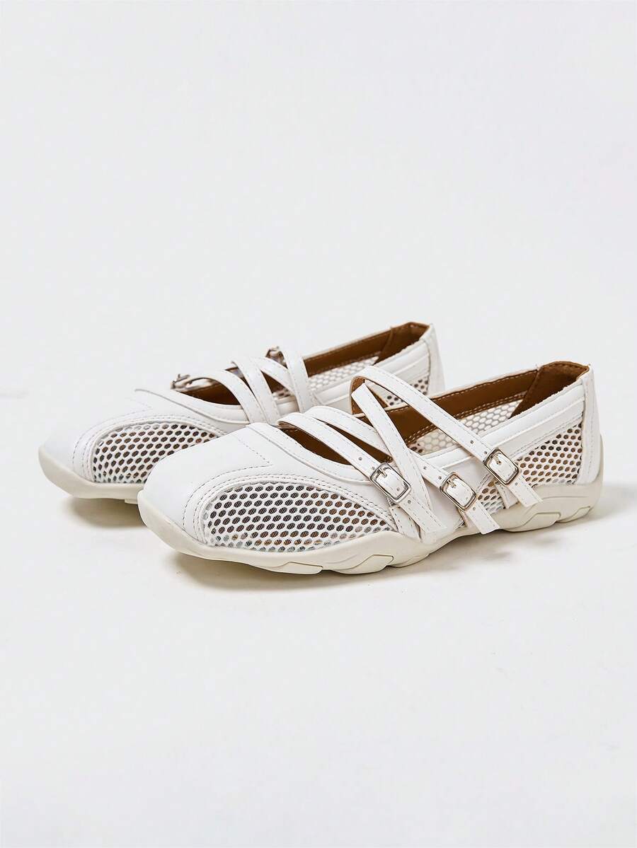 Front three-quarter view of white three-strap Mary Jane flats with mesh panels and segmented sole