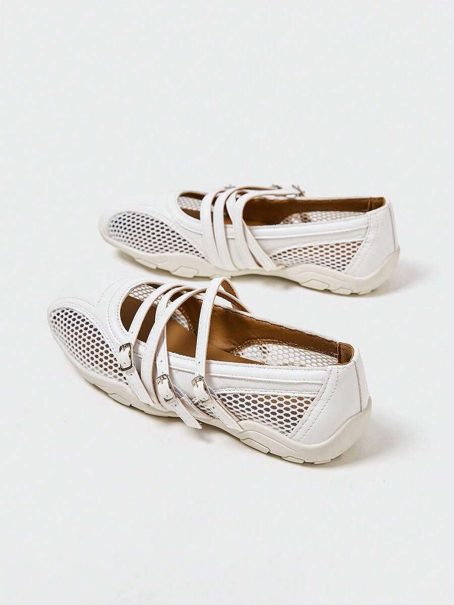 Rear-side view of white buckle-strap Mary Jane flats with mesh panels and low off-white sole