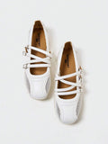 Overhead view of white rounded-square toe Mary Jane flats with three buckle straps