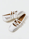 Angled overhead view of white three-strap mesh Mary Jane flats with segmented sole