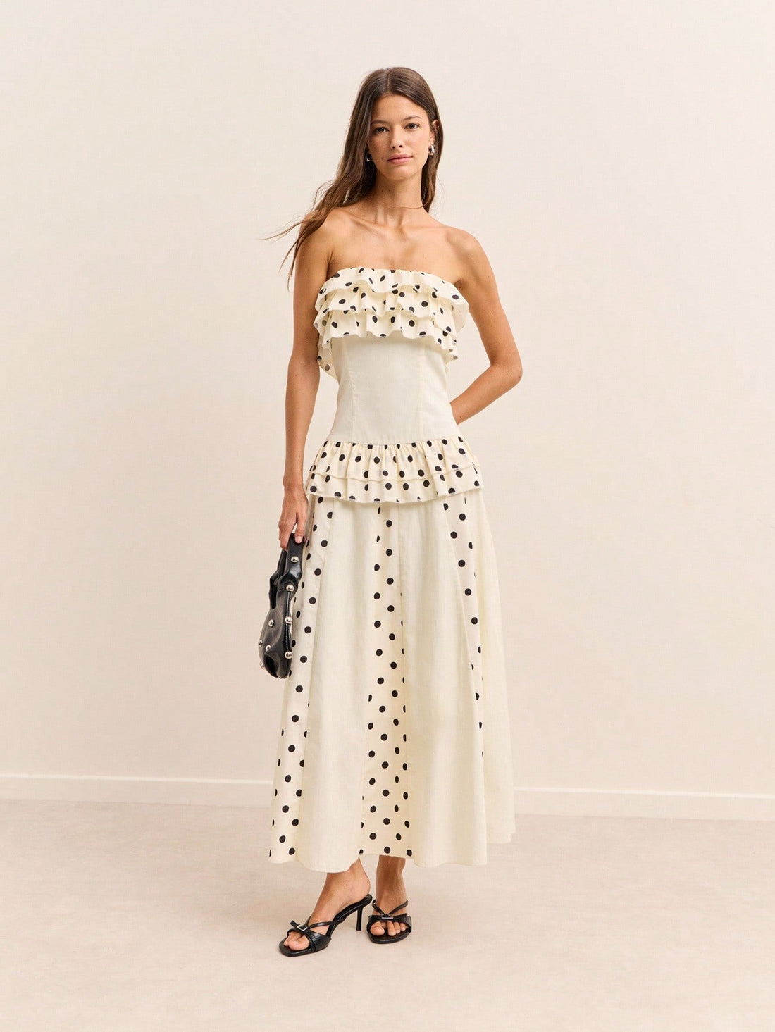Step into retro-inspired elegance with this cream maxi dress that brings Y2K nostalgia straight to your wardrobe. Adorned with classic black polka dots and featuring charming ruffled layers, this piece effortlessly blends vintage vibes with modern flair. Perfect for making a statement at brunches, date nights, or any occasion where you want to turn heads. The flowing silhouette flatters every figure while the playful polka dot pattern keeps things fun and flirty. Embrace your inner fashion icon and let this
