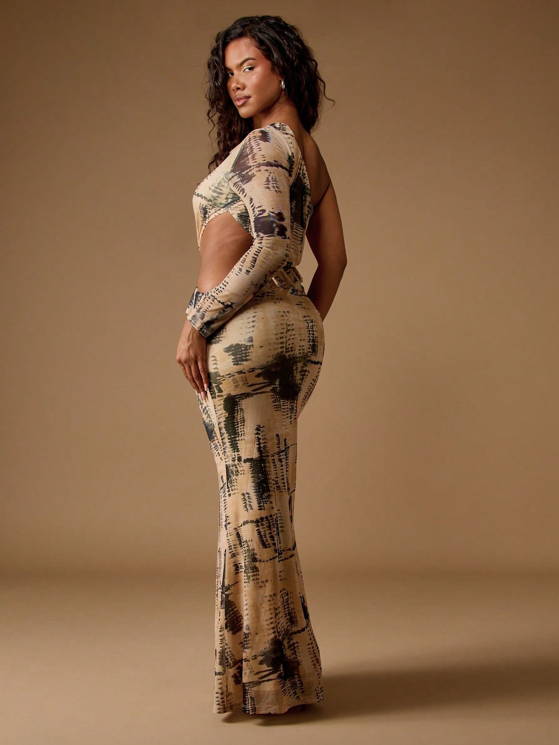 Make a statement in this show-stopping one-sleeve maxi dress that's equal parts bold and elegant. The daring cut-out detail and eye-catching abstract print create an unforgettable silhouette perfect for turning heads at evening soirées and cocktail celebrations. Slip into sophistication with a design that proves you don't need to cover everything to look absolutely fabulous. Whether you're dancing the night away or mingling in style, this dress delivers drama, confidence, and pure glamour in one stunning pa