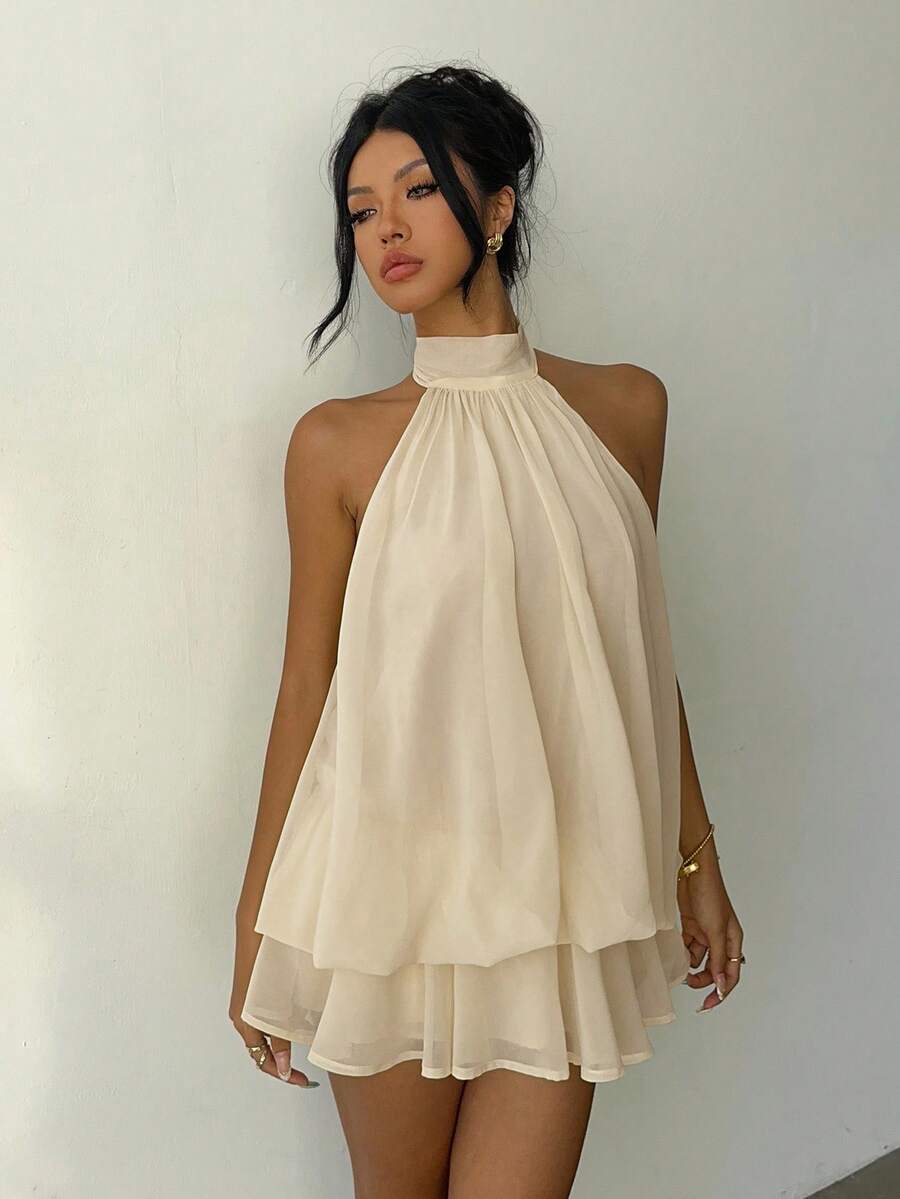 Full front view of beige backless halter mini dress styled for summer travel