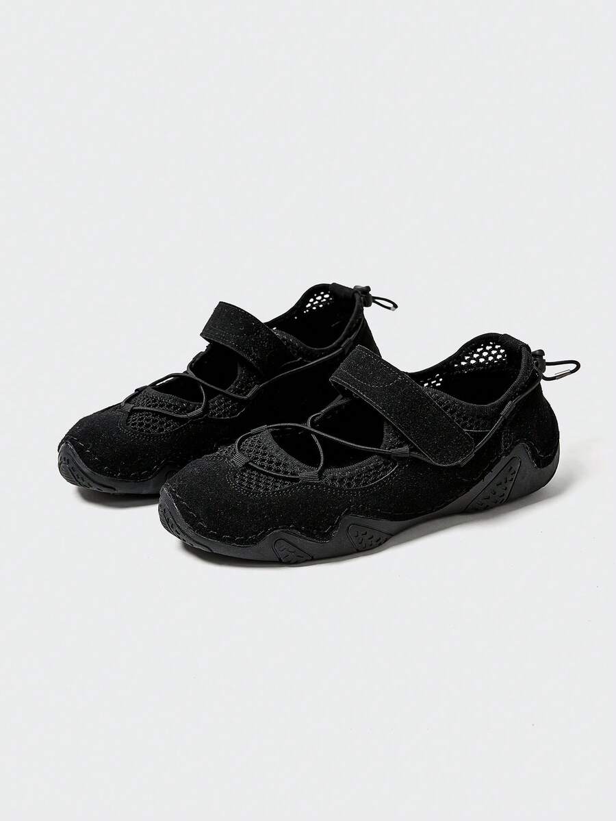 Front-quarter view of black mesh water shoe with hook-and-loop strap and patterned sole