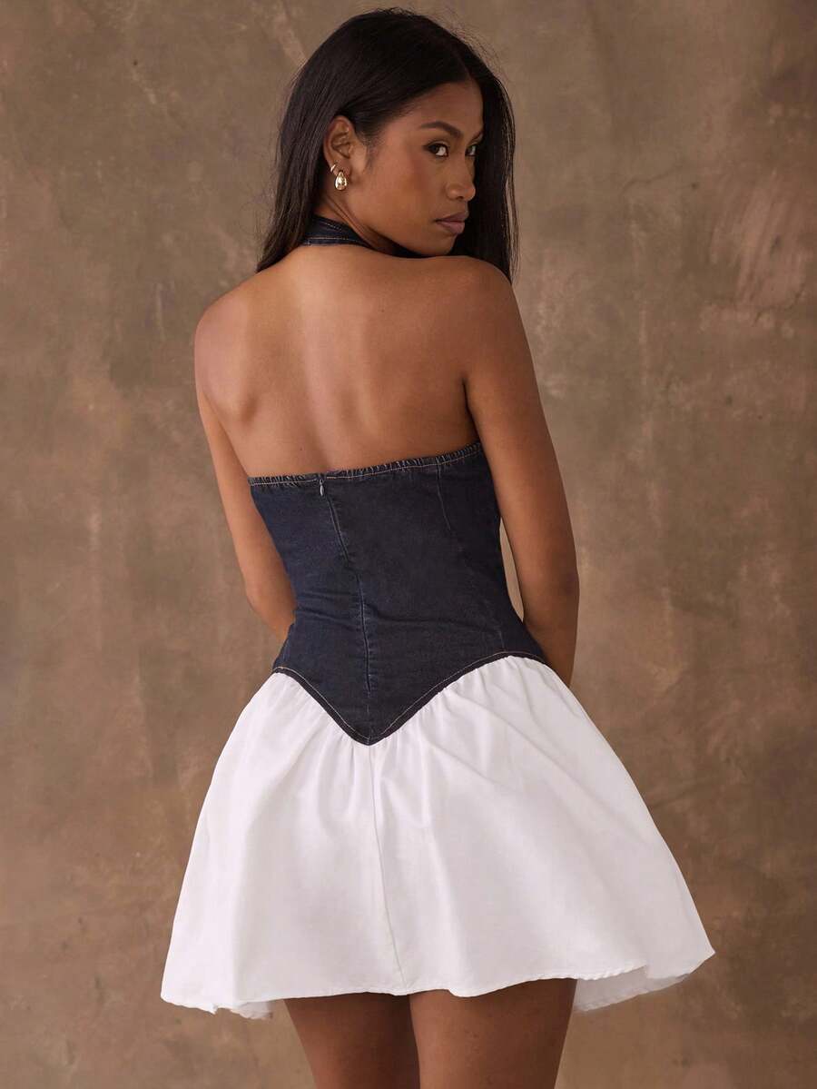 Back view of open-back denim halter mini dress with zipper and flared skirt