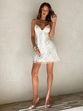 Side view of ivory white floral embroidered spaghetti strap mini dress with side skirt movement