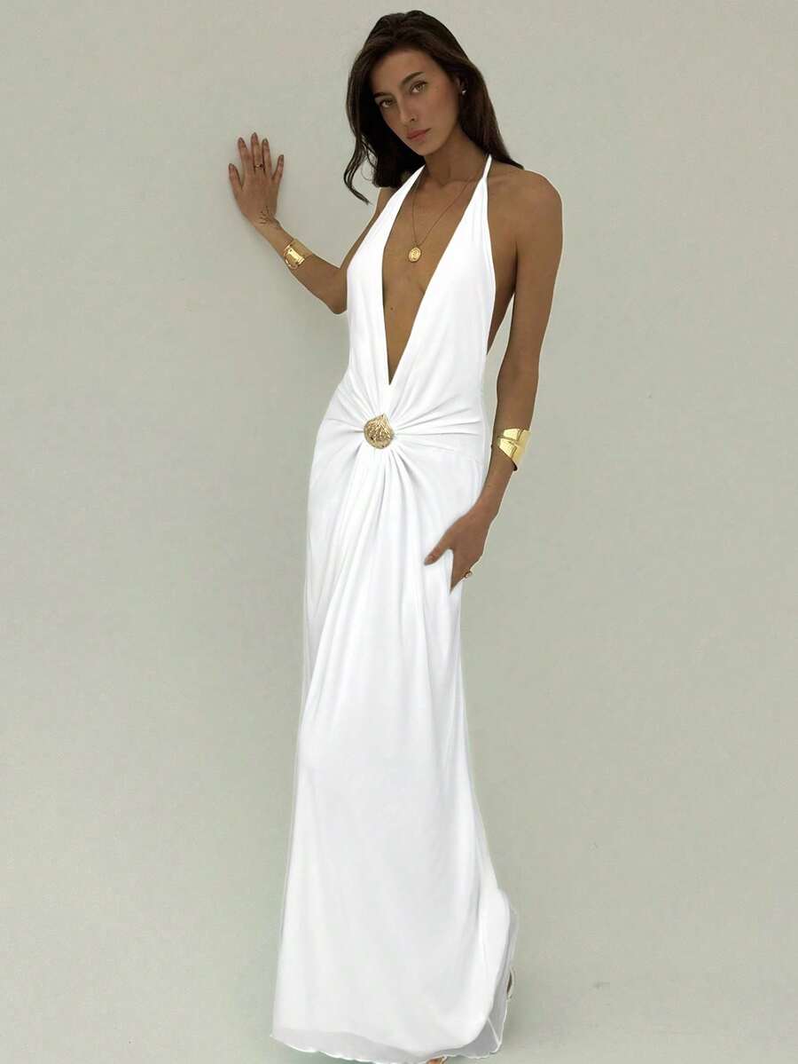 Angled full view of white backless halter maxi dress with flowing skirt