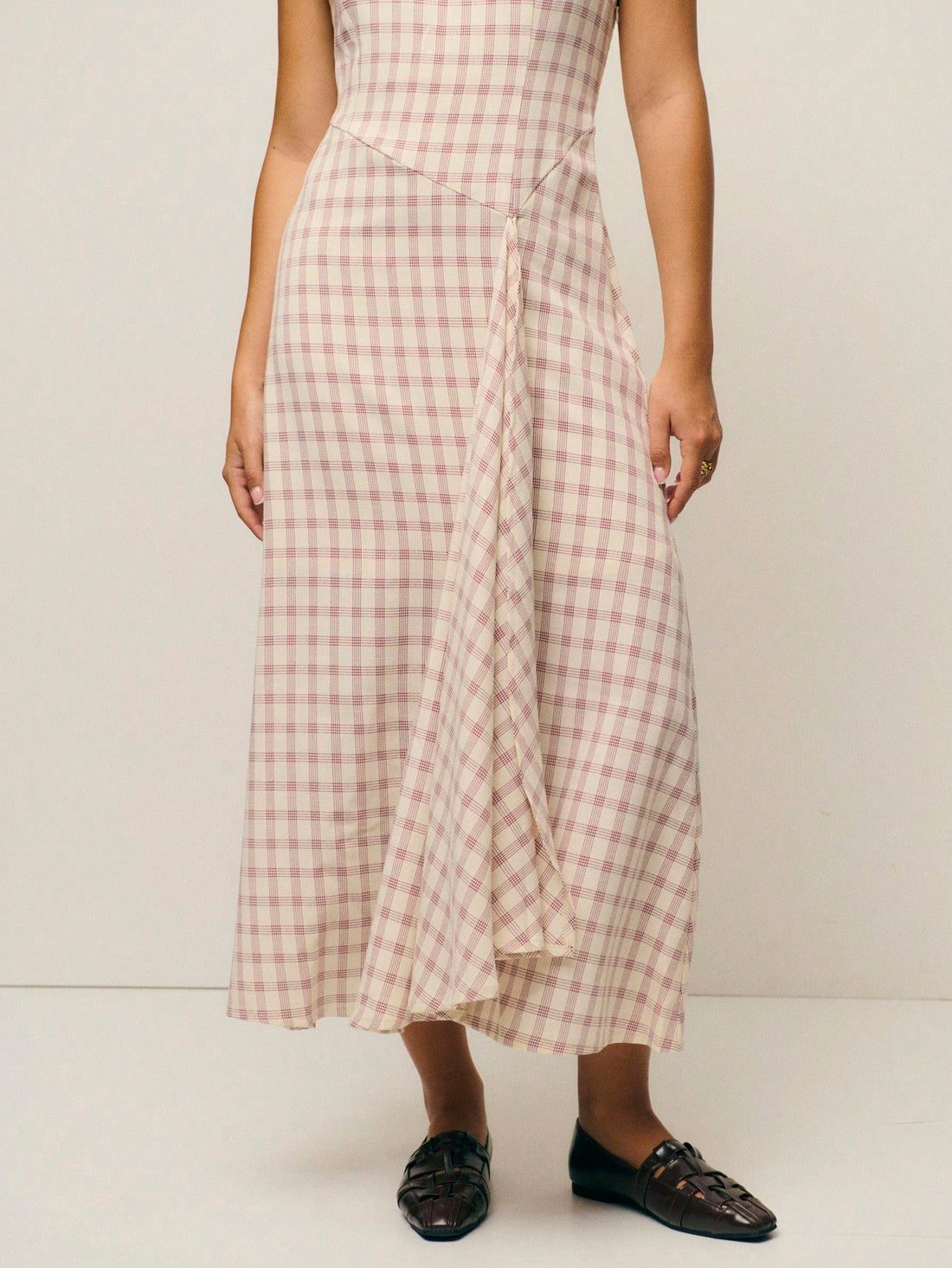 Step into effortless sophistication with this charming pink checked midi dress. The sleek sleeveless silhouette and high round neckline create a timeless, polished look that transitions seamlessly from brunch to evening plans. The classic gingham pattern adds a touch of vintage-inspired whimsy, while the midi length offers graceful coverage and flattering proportions. Perfect for anyone who loves a dress that's both put-together and playfully chic—pair it with your favorite sneakers for casual vibes or dres