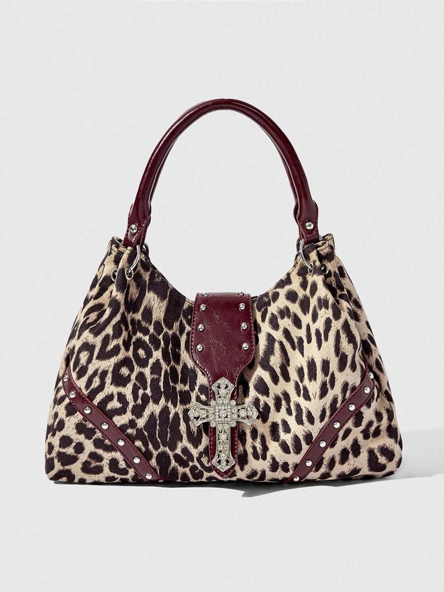 Close-up of sparkling silver cross hardware on patterned shoulder bag
