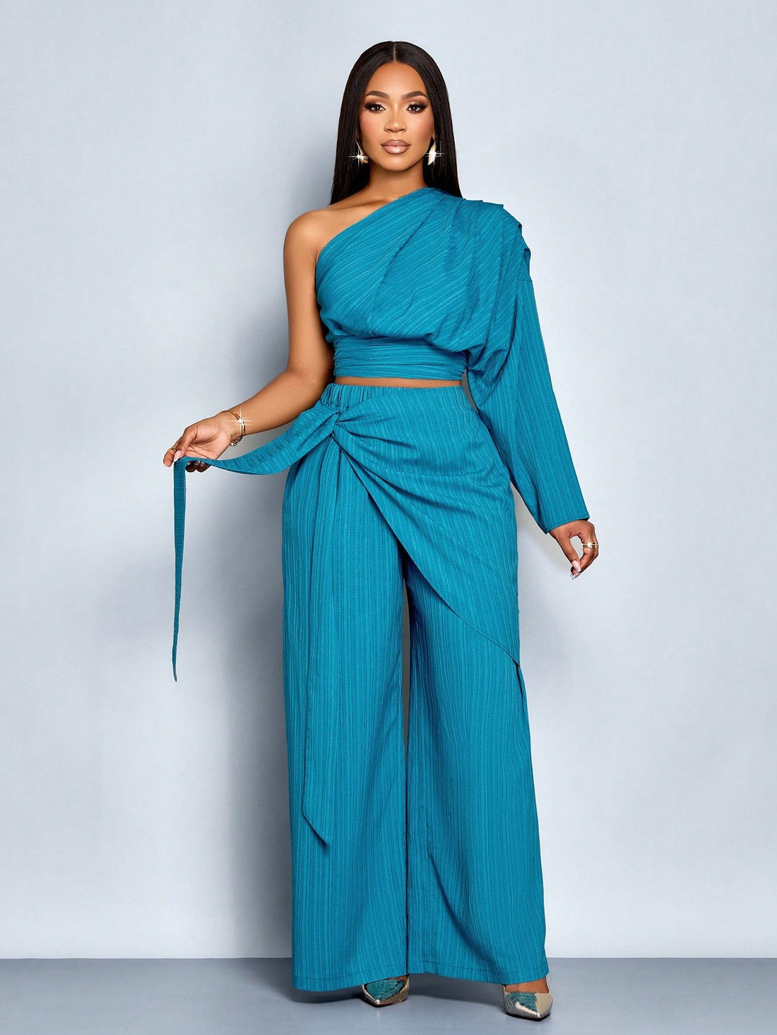 Elevate your winter wardrobe with this show-stopping two-piece set that's basically a shortcut to looking effortlessly put-together. The one-shoulder pleated blouse brings drama and sophistication, while the belted high-waist wide-leg pants deliver that coveted polished silhouette. Whether you're heading to brunch, the office, or a night out, this dynamic duo works overtime to keep you looking chic without the fuss. Mix, match, or wear together—either way, you're winning the style game.
