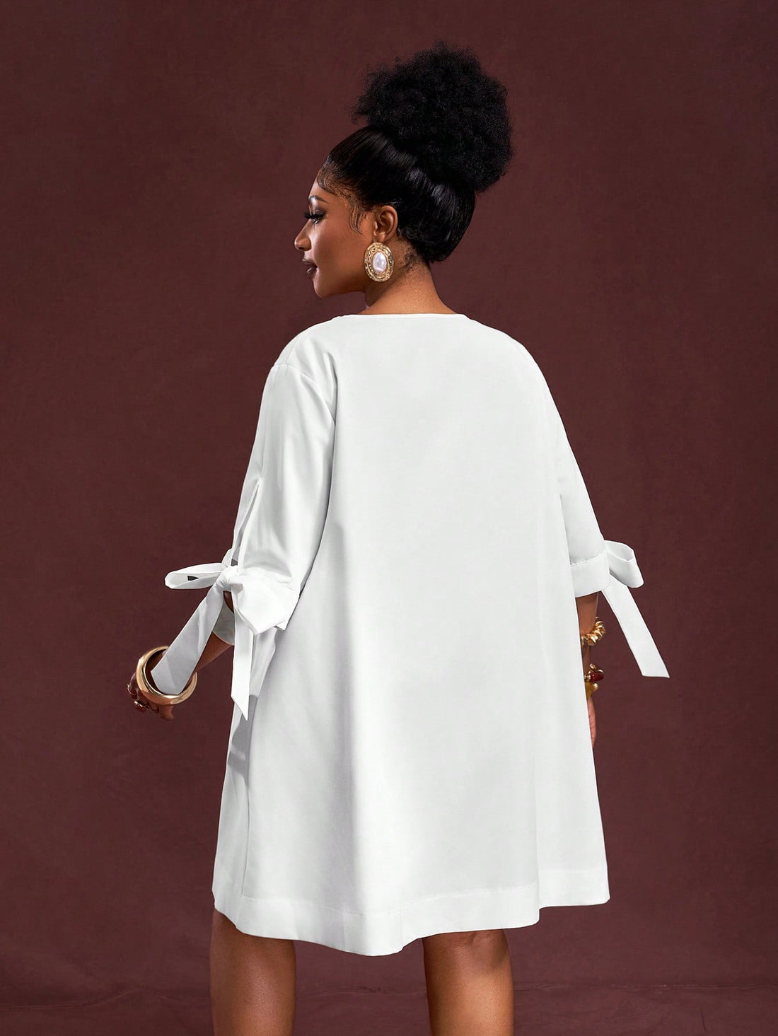 This playful plus size white mini dress features a flattering V-neck and a charming tie front, perfect for sunny summer vacations. Its breezy A-line silhouette keeps you comfortable and effortlessly chic, whether you’re exploring a new city or lounging by the beach. Add a splash of fun to your warm-weather wardrobe with this versatile and stylish summer essential.