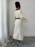 Back view of cream and brown rib-knit A-line midi dress with high waist and long bishop sleeves
