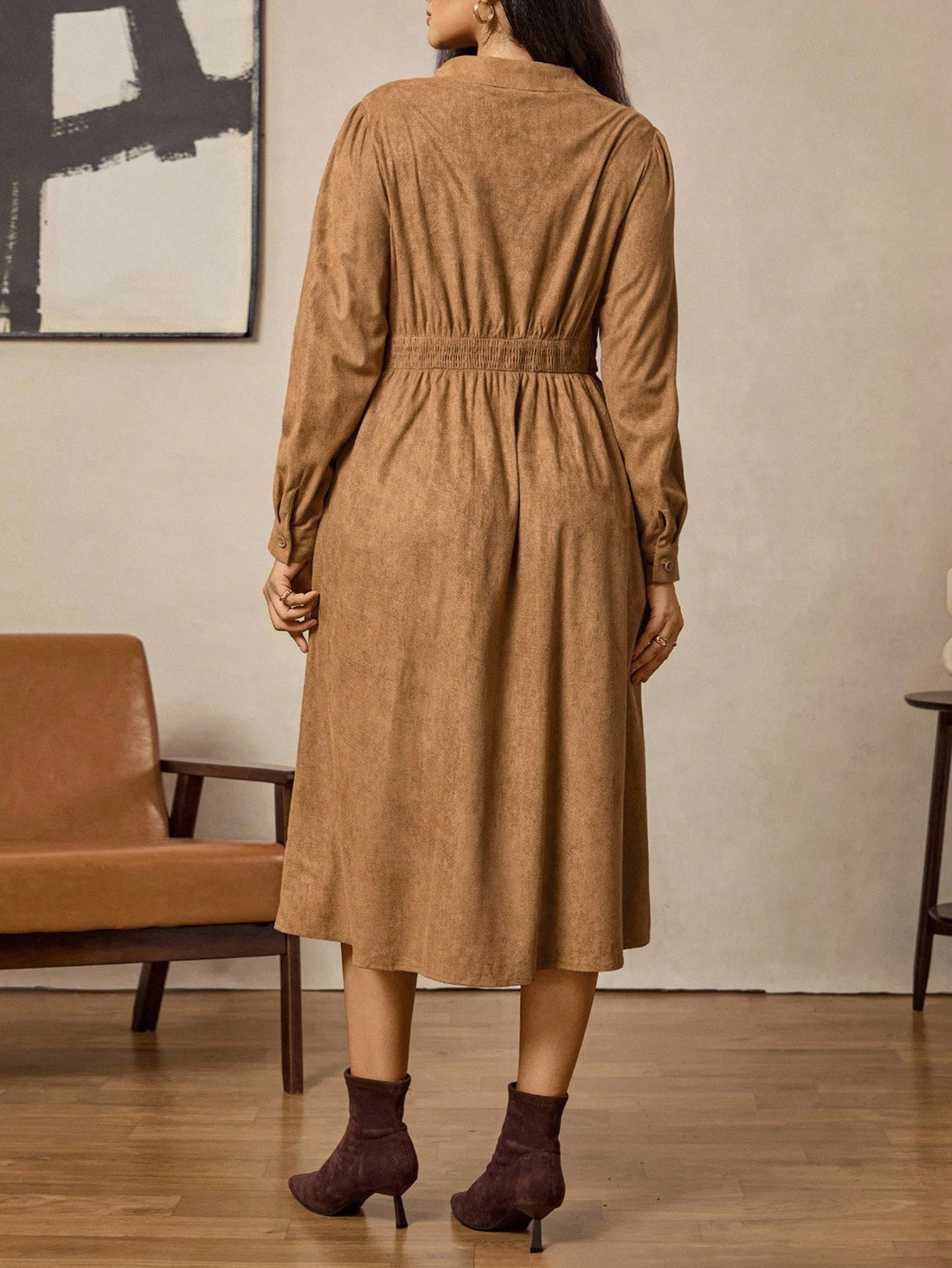 Step into autumn with a playful twist wearing this elegant plus size shirt dress. Crafted from soft brown suede, it features a charming vintage coin pattern that adds a touch of whimsy to your wardrobe. The long sleeves keep you cozy as the temperatures dip, while the flattering cut embraces your curves with confidence. Perfect for layering or wearing solo, this dress brings vintage charm and autumn warmth together in one stylish package.
