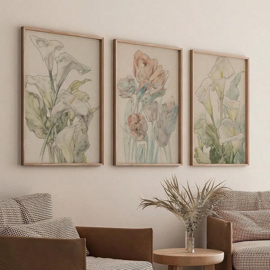 Set of three watercolor tulip and lily canvas prints above a white sofa in a boho room