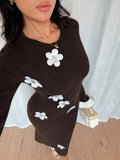 High angle view of brown bodycon midi dress with white 3D rose appliques and round neckline