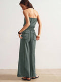 Back view of dark slate green strapless jumpsuit with gathered waist and rear pockets