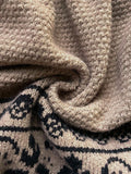 Close up of taupe textured knit and black jacquard pattern