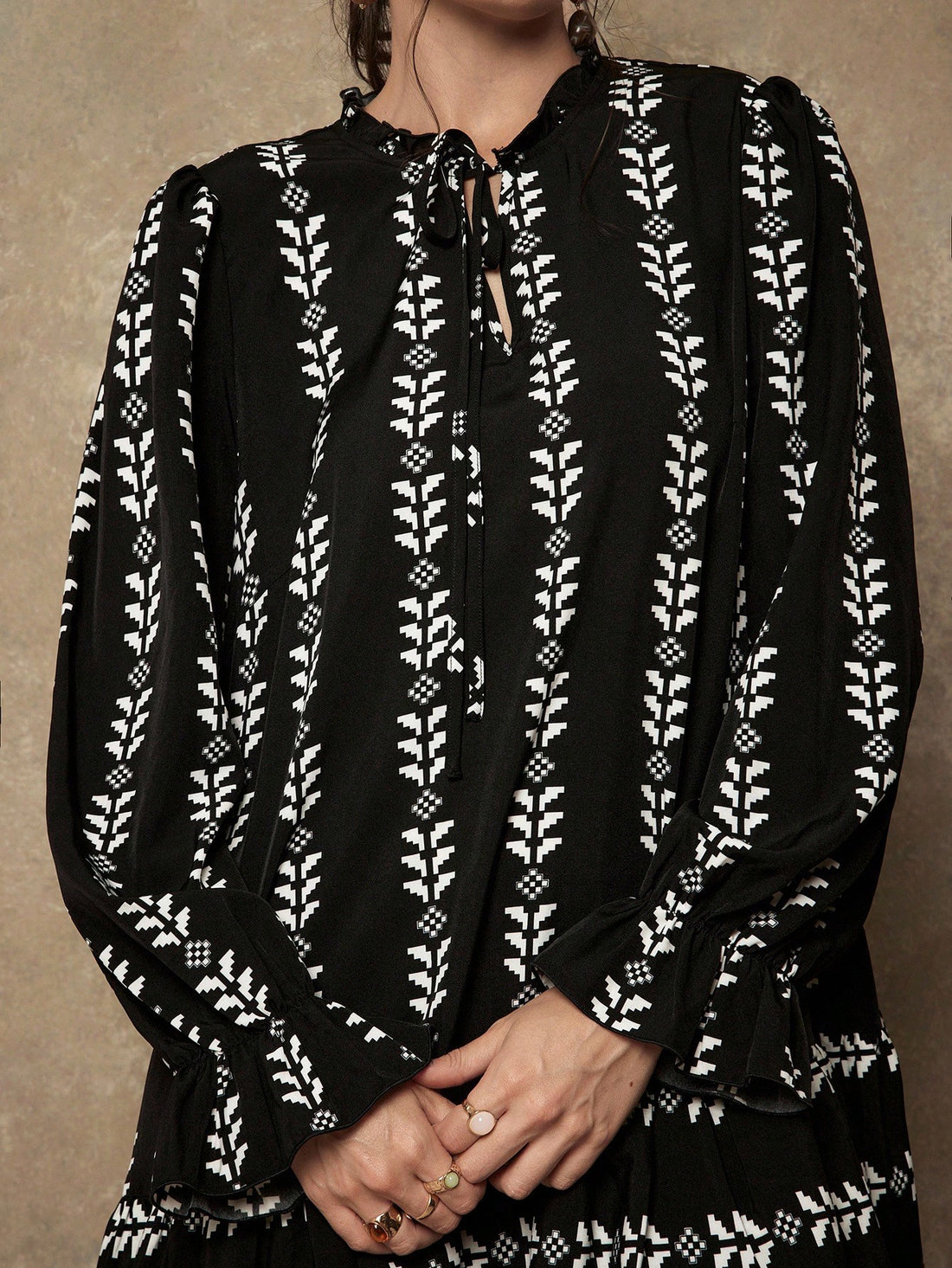 Make a statement with this playful plus-size dress that brings together bold geometric prints and charming details. The tie collar adds a flirty touch while long sleeves provide comfortable coverage, perfect for transitioning between seasons. A ruffled hem gives you that extra dash of personality and movement. Whether you're heading to brunch or a casual day out, this dress celebrates your curves with style and confidence. Effortlessly chic and undeniably fun.